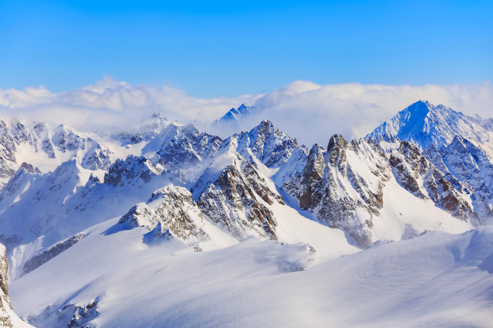 Snow-covered Swiss Alps peaks under a bright winter sky, showcasing pristine alpine beauty